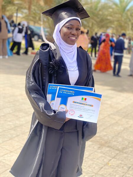 Khady, diplômée infirmière d'État, présente son attestation de réussite